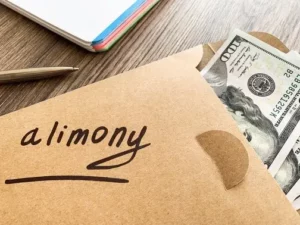 Brown envelope with money in it and the word alimony written on the envelope
